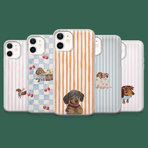 Könnte beinhalten: Fünf Handyhüllen mit Dackel-Designs. Die Hüllen zeigen verschiedene Muster, darunter vertikale Streifen, Karomuster und Hundeillustrationen mit Kirschen und Blumen. Die Hüllen sind in den Farbtönen Rosa, Blau und Orange gehalten.