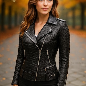 Może przedstawiać: Czarna skórzana kurtka z teksturowanym wzorem, zapięciem na zamek i wieloma kieszeniami. Kurtka ma klasyczny styl motocyklowy z kołnierzem z klapami i srebrnymi elementami. Logo marki "VH" jest widoczne w lewym górnym rogu.