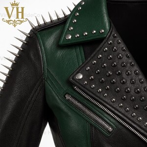 May include: A black and green leather jacket with silver metal spikes and studs. The jacket features a notched collar, an asymmetrical zipper, and a contrasting green panel on the shoulder and lapel.