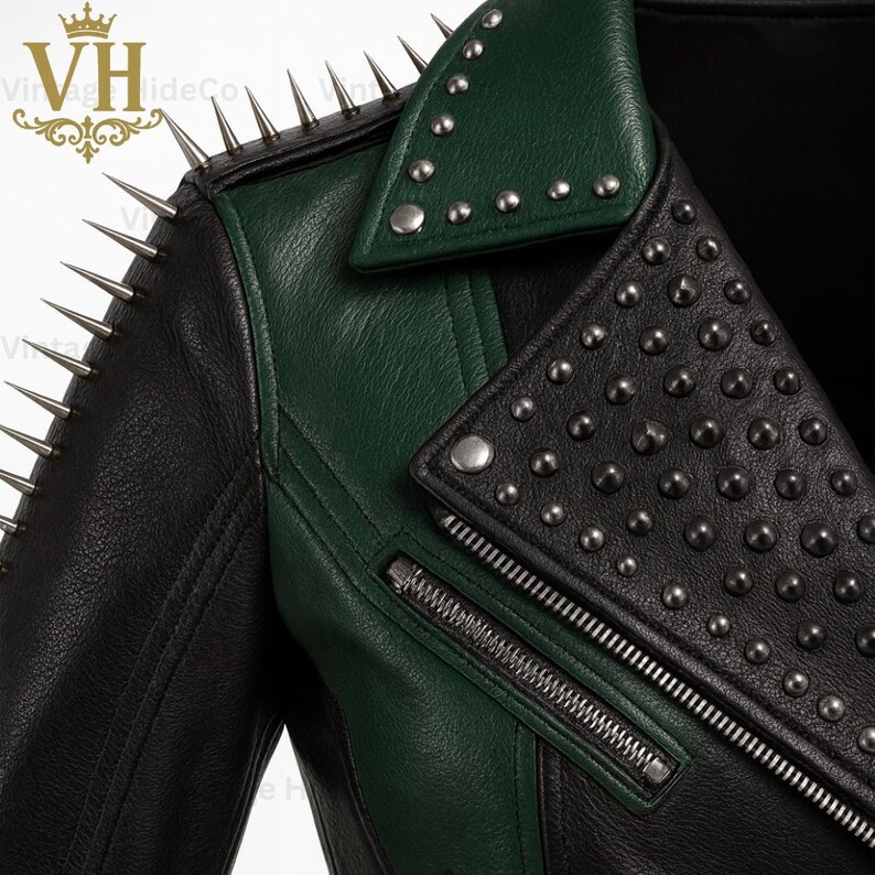 May include: A black and green leather jacket with silver metal spikes and studs. The jacket features a notched collar, an asymmetrical zipper, and a contrasting green panel on the shoulder and lapel.