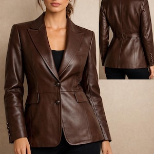 May include: A brown leather blazer with a classic tailored design. Features include a notched lapel, two front pockets, and button closures. The blazer has a fitted silhouette and a belt detail at the back. The image also shows a close-up of the buttons.