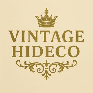 May include: A gold-colored logo on a cream background. The logo features the words "VINTAGE HIDECO" in a serif font, with a gold crown above and an ornate flourish below. The design has a vintage aesthetic.