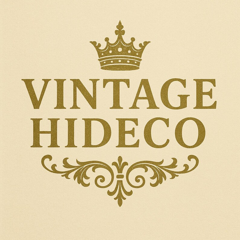 May include: A gold-colored logo on a cream background. The logo features the words "VINTAGE HIDECO" in a serif font, with a gold crown above and an ornate flourish below. The design has a vintage aesthetic.