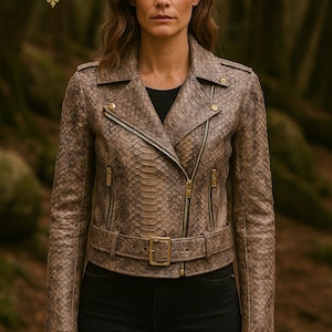 Könnte beinhalten: Braune Lederjacke mit Schlangenmuster, mit Gürtel in der Taille und goldfarbenen Beschlägen. Die Jacke hat einen klassischen Biker-Stil mit einem Reverskragen, asymmetrischem Reißverschluss und mehreren Reißverschlusstaschen. Die Person trägt ein schwarzes Oberteil.