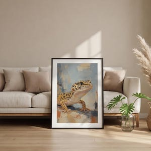 May include: A framed wall art print featuring an oil painting of a leopard gecko with yellow and black spotted skin. The gecko is positioned against a textured, abstract background of light blue, white, and earthy orange brushstrokes.