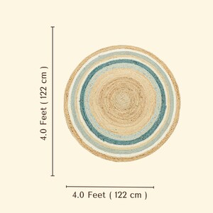 May include: A round braided rug featuring concentric circles of natural tan, light blue, and dark teal fibers. The rug measures 4.0 feet (122 cm) in diameter as indicated by the text labels on the side and bottom of the image.