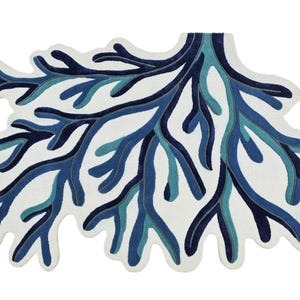 May include: A rug shaped like a branching coral structure featuring a white background with layered, organic patterns in shades of navy blue, royal blue, and teal. The design consists of intricate, interconnected limbs that spread outward.
