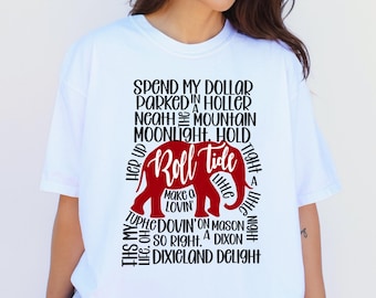 May include: A white short-sleeved t-shirt featuring a red elephant graphic in the center. The text surrounding the elephant reads: Spend my dollar, parked in a holler, neath the mountain moonlight, hold her up, Roll Tide, make a lovin', little, tight, a, night, this my life, oh, so right, a, Dixon, Dixieland Delight.