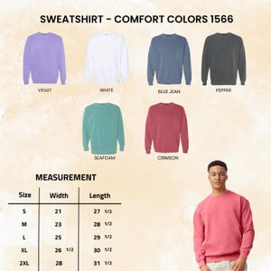 May include: A selection of Comfort Colors 1566 sweatshirts in various colors, including violet, white, blue jean, pepper, seafoam, and crimson. The image also includes a measurement chart with sizes S to 2XL, detailing width and length in inches.