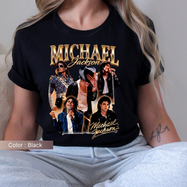 May include: Black t-shirt featuring a collage of images of Michael Jackson with the text "MICHAEL Jackson" in gold lettering. The shirt showcases various iconic poses of the artist, capturing his dynamic stage presence.