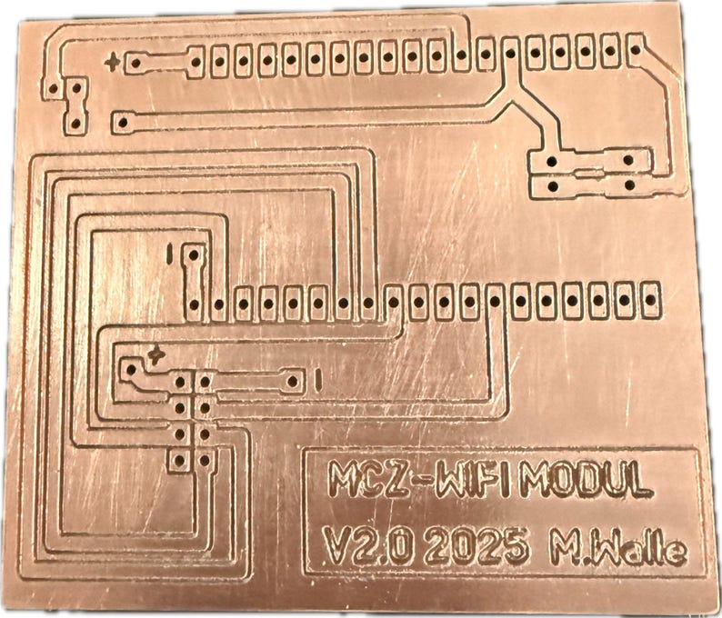 May include: A copper-coloured printed circuit board with etched pathways and numerous connection points. The board features the text "MCZ-WIFI MODUL V2.0 2025 M.Walle". The design includes rectangular pads and traces, suggesting an electronic component.