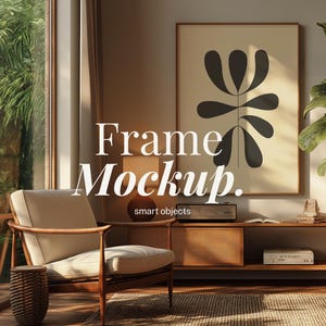 May include: Interior scene with a framed art print featuring a black abstract floral design. A mid-century modern chair, a woven side table, and a wooden cabinet with a record player are in the room. The text "Frame Mockup" is displayed.