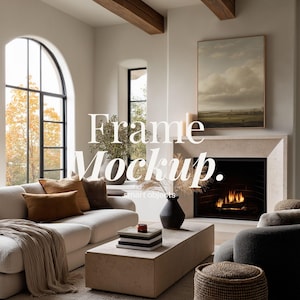 May include: A living room scene with a white sofa, brown pillows, and a beige throw blanket. A coffee table displays books and a black vase. The text "Frame Mockup" is visible. A fireplace with a painting above it is also present.