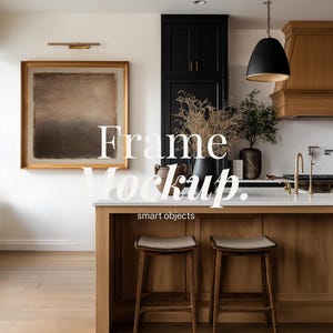 Può includere: Interno cucina con isola in legno e due sgabelli da bar. Un'opera d'arte incorniciata è appesa alla parete e il testo "Frame Mockup. smart objects" è sovrapposto. Una lampada a sospensione nera è appesa sopra l'isola.