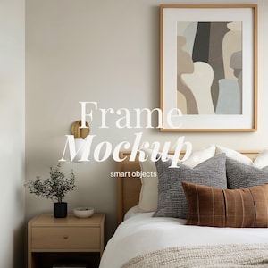 Puede incluir: Interior de dormitorio con una obra de arte abstracta enmarcada en un marco marrón claro. La cama está hecha con ropa de cama blanca, cojines decorativos y una manta tejida. El texto "Frame Mockup" y "smart objects" es visible.