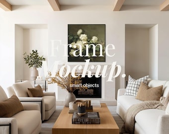May include: A living room scene with a large framed floral painting above a fireplace. The room features cream-colored sofas, a wooden coffee table, and decorative vases. The text "Frame Mockup. smart objects" is overlaid on the image.