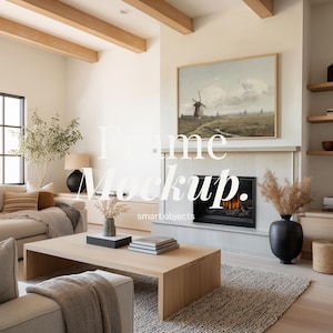May include: A living room scene with a light wood coffee table, a beige sofa, and a framed landscape painting above a fireplace. The room features a neutral color palette with wooden beams and a textured rug. The text "Frame Mockup" is visible.