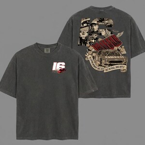 May include: Dark grey t-shirt with a red and white "16" logo and a race car graphic on the front. The back of the shirt features a collage with the text "In Loving Memory 1969-2023 Best in Peace, Greg Biffle."