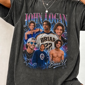 Op de afbeelding: Donkergrijs t-shirt met een retro design met de tekst "JOHN LOGAN" en een collage van afbeeldingen. De collage bevat afbeeldingen van een man in verschillende poses, waaronder een met een "BRIAR 22" trui. Het shirt heeft een vintage, versleten uitstraling.