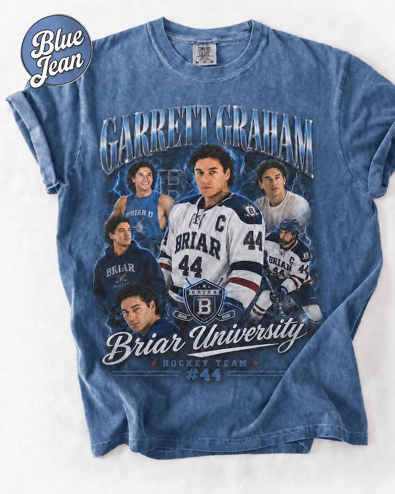 May include: Blue t-shirt featuring a graphic of Garrett Graham, Briar University Hockey Team #44. The design includes images of the player in various poses, with the team name and logo prominently displayed. The shirt has a vintage, faded look.