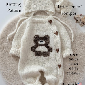 May include: A cream-coloured knitted baby romper set with a bear design, a matching hat with bear ears, and booties. The romper features brown heart-shaped buttons and a bear applique. The text "Little Fawn" and "Knitting Pattern" are visible.