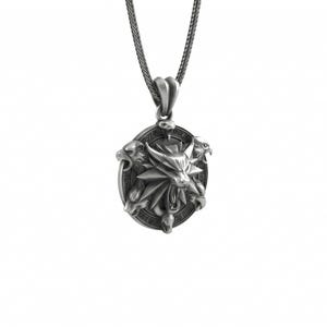 May include: Silver-toned pendant necklace featuring a detailed oval pendant with a wolf's head emblem and three stylized animal heads. The pendant hangs from a matching chain, creating a striking accessory. The design is set against a white background.