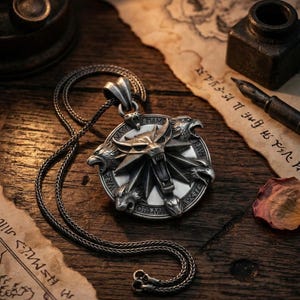 May include: A silver pendant necklace featuring a circular pendant with a wolf's head and other animal heads. The pendant is on a dark chain, and the image is set on a wooden surface with old paper and an inkwell.