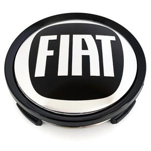 Peut inclure: Un emblème de voiture Fiat noir et argent. L'emblème présente le mot "FIAT" en lettres blanches grasses sur un fond noir, entouré d'une bordure argentée et d'un anneau extérieur noir.