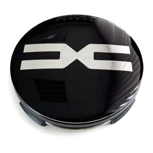 May include: A black and silver car wheel center cap with a shiny finish. The cap features a silver logo in the center, composed of two mirrored "E" shapes. The cap is round and has a black outer ring.