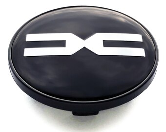 May include: A black hubcap with a white logo. The logo features two horizontal lines with a stylized "X" in the center. The hubcap is round and has a glossy finish.