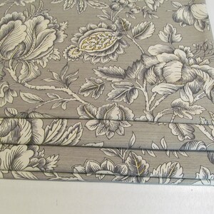 May include: Gray and white floral patterned fabric with a subtle sheen. The fabric is pleated and has a delicate floral design.
