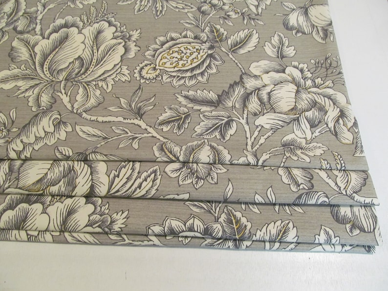 May include: Gray and white floral patterned fabric with a subtle sheen. The fabric is pleated and has a delicate floral design.