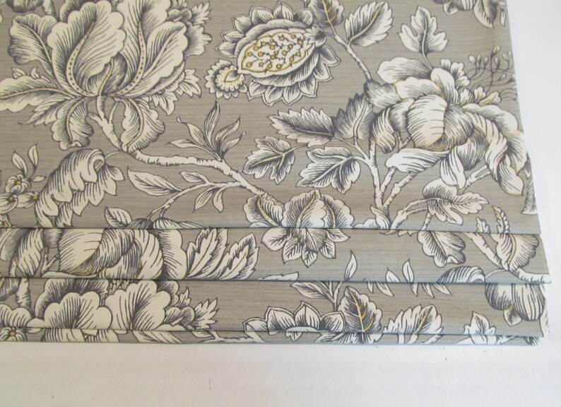 May include: Gray fabric with a white and black floral pattern. The fabric is pleated and has a subtle sheen.