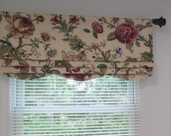 May include: A cream-colored valance with a scalloped bottom edge features a floral pattern in shades of red, green, and brown. The valance is hung on a brown metal rod.