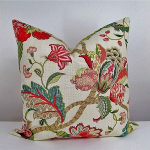 May include: A decorative cushion with a floral pattern featuring red, pink, green, and brown flowers on a cream background.