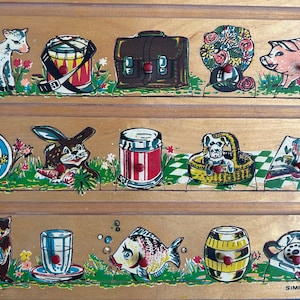 May include: A vintage wooden puzzle featuring colorful illustrations of various objects and animals. The puzzle includes images of a lamb, drum, briefcase, flowers, pig, beach ball, rabbit, can, dog in a basket, book, beaver, glass, fish, barrel, and a telephone.