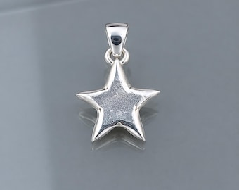May include: A silver-toned star-shaped pendant featuring a polished, smooth outer border and a textured, matte-finish center. The pendant includes a small, integrated bail at the top for attachment to a chain, showcasing a metallic luster.