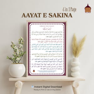 Puede incluir: Una impresión enmarcada con texto árabe, titulada "AAYAT E SAKINA", que presenta versos del Corán. La impresión tiene un borde blanco y se muestra en un estante de madera con elementos decorativos, incluido un jarrón con plantas secas. Las palabras "Descarga digital instantánea" están en la parte inferior.