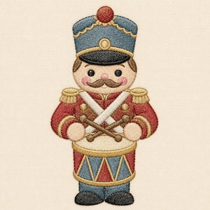 Puede incluir: Un diseño bordado de un soldado de juguete con un sombrero azul con un pompón rojo, una chaqueta roja con charreteras doradas y pantalones azules. La figura tiene un bigote marrón y sostiene dos baquetas sobre un tambor con triángulos azules y rojos.