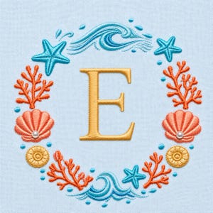 May include: Embroidered design featuring a gold letter "E" surrounded by a wreath of ocean elements. The wreath includes turquoise starfish, orange coral, peach seashells with pearls, and blue waves, all on a light blue background.