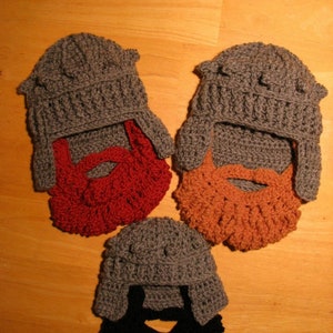 May include: Three crocheted hats with beards attached. The hats are gray and the beards are red, orange, and black.