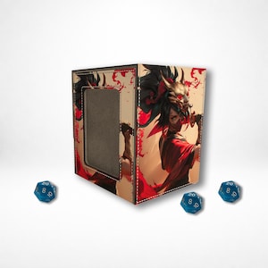 May include: A beige dice box with a warrior illustration in red and gold. The box has a rectangular opening and is surrounded by three blue dice with white numbers.