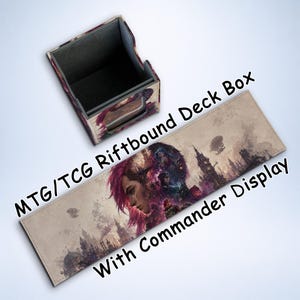 May include: A deck box and Commander display mat with the text "MTG/TCG Riftbound Deck Box With Commander Display." The box is rectangular with a purple and gray design. The mat features a fantasy cityscape and a character with pink hair.