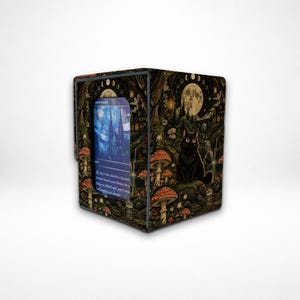 May include: A rectangular deck box featuring a dark forest illustration with a black cat, red mushrooms, and a full moon. A blue trading card with text is visible through a rectangular cutout on the front panel of the container.