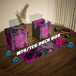Op de afbeelding: Een assortiment MTG/TCG deck accessoires, waaronder een deckbox, kaarthouder en speelmat. De items hebben een levendig ontwerp met roze, zwarte en blauwe accenten. Verschillende blauwe dobbelstenen en een klein boek liggen ook op de houten tafel.