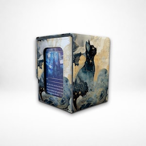 May include: A square card storage box with a watercolor design. The box features a black cat silhouette against a backdrop of blue and gold clouds and stars. A card is visible in the opening, displaying a blue and white image.