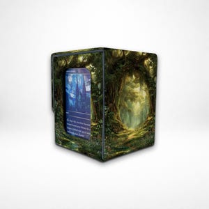 May include: A card storage box with a forest scene design. The box features a vibrant green and brown forest illustration with a card visible on the front. The card has a blue and white image of a castle.