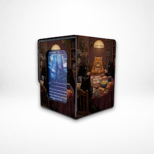 May include: A square deck box featuring a printed illustration of several cats sitting around a round table playing cards. One side of the box displays a rectangular window showing a blue stained-glass style card with visible text.