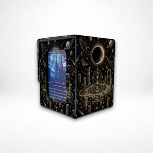May include: A black deck box for trading cards featuring a gold celestial illustration of a moon, planets, and stone ruins. A rectangular window on the front displays a blue and white card with text, including the words Pay 1 life, Sacrifice Flooded.