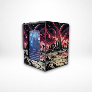 May include: A rectangular deck box for trading cards featuring a dark, science fiction landscape with cracked earth, tall spires, and red celestial bodies in the sky. A single trading card is visible through a cutout window on the front panel.